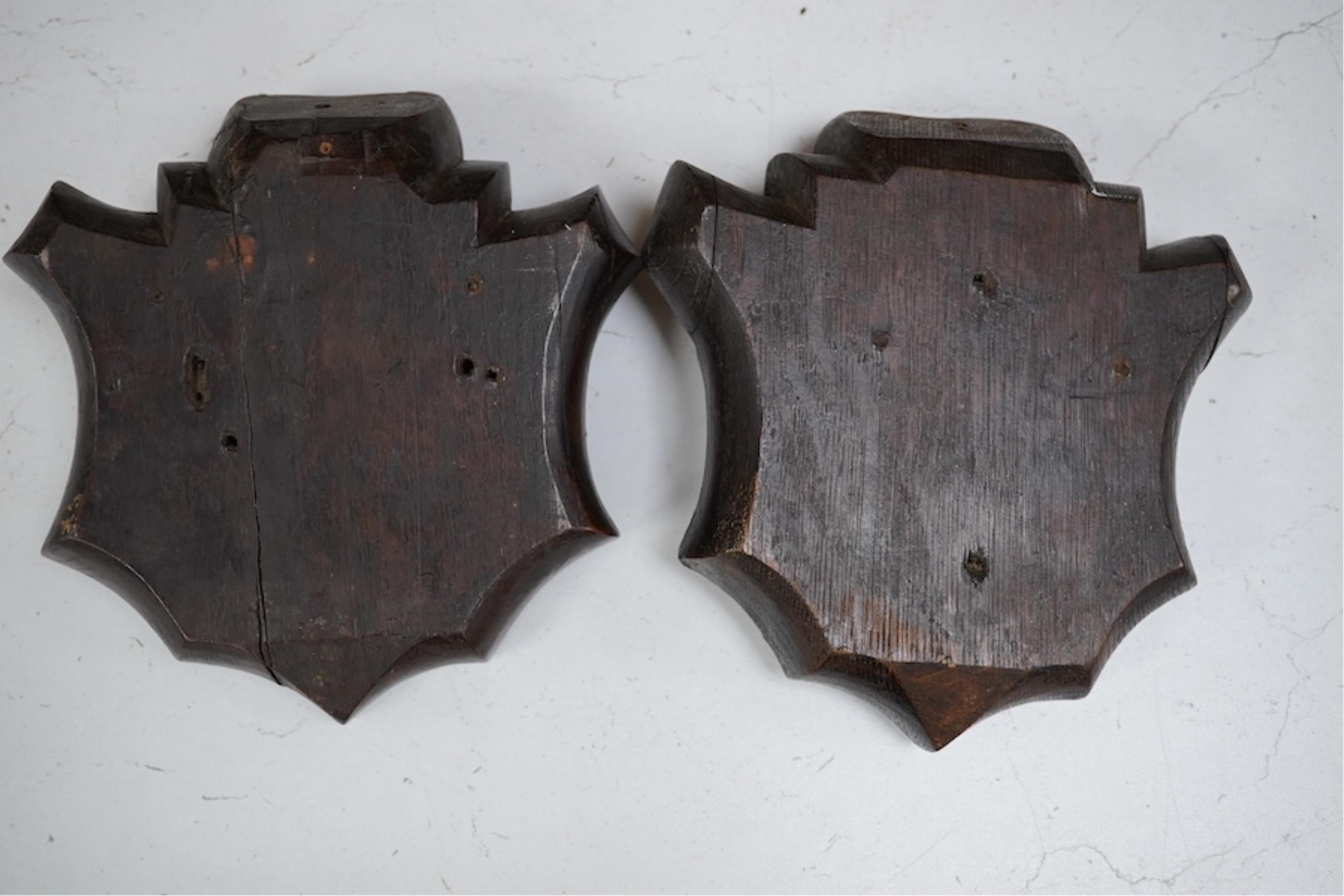 A pair of 19th century carved oak shields, one of an angel the other an eagle. 19.5cm high. Condition - good